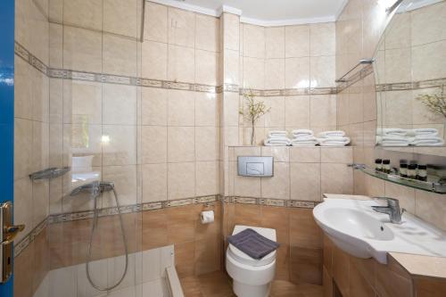a bathroom with a shower and a toilet and a sink at Palma Village by Greek Pride Hotels in Skála Foúrkas