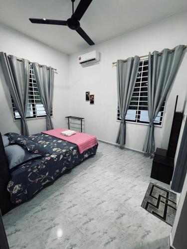 a bedroom with a bed and two windows at Homestay CikguMa 4 - Wi-Fi in Kota Bharu