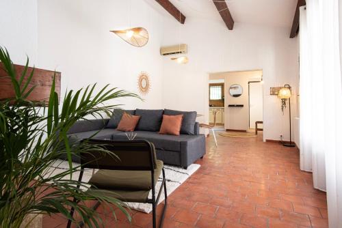 a living room with a blue couch and some plants at Maison et Studio, Olivier I Sirocco in Istres