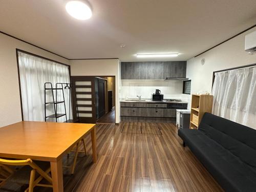 a kitchen and a living room with a table and a couch at Asakusa Riverside Family Inn in Tokyo
