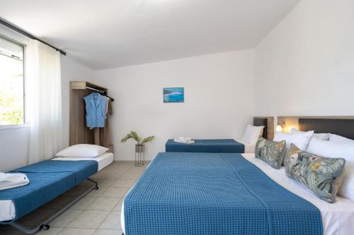 two beds in a room with blue and white at Palma Village by Greek Pride Hotels in Skála Foúrkas