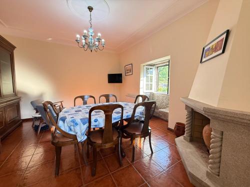 a dining room with a table and chairs and a chandelier at Casa dos Patricios in Terras de Bouro