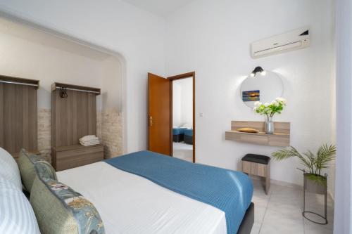 a bedroom with a bed and a mirror at Palma Village by Greek Pride Hotels in Skála Foúrkas