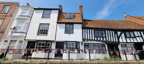 a white and black house with a fence at Historic, Jacobean House, Old Town Hastings in Hastings