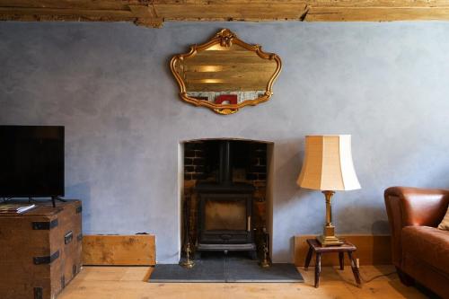 a living room with a fireplace and a mirror on the wall at Historic, Jacobean House, Old Town Hastings in Hastings