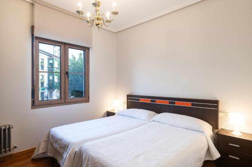 a bedroom with a large bed and a window at Apartamento La Vega de Santiago 1 in Posada de Llanes