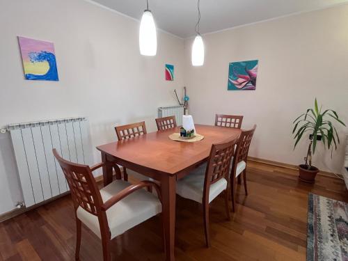 a dining room with a wooden table and chairs at Noa & Dan in Koper