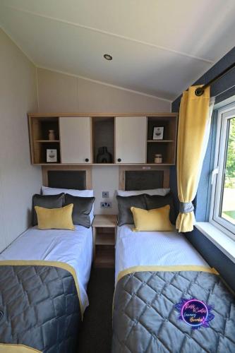 two beds in a room with a window at Big Duffs Den in Tattershall