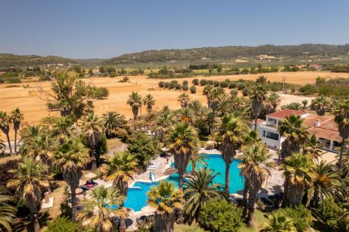 an aerial view of a resort with palm trees at Palma Village by Greek Pride Hotels in Skála Foúrkas