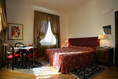 a bedroom with a bed and a table and a window at La Torre Hotel in Moie
