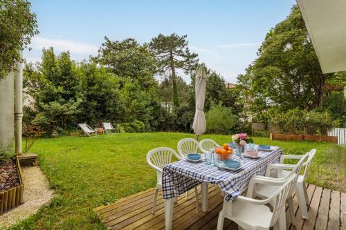 une table et des chaises sur une terrasse dans une cour dans l'établissement Maison du Brise Lames - Welkeys, à Anglet
