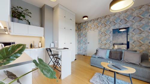ein Wohnzimmer und eine Küche mit Sofa und Tisch in der Unterkunft Wroclove Apartments in Breslau