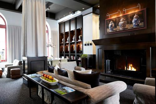 a living room with a couch and a fireplace at Hôtel Le Germain Québec in Quebec City