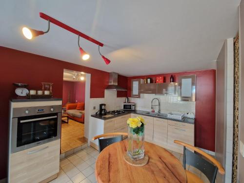 a kitchen with a table with a vase of flowers on it at gites de l'archange in Courtils