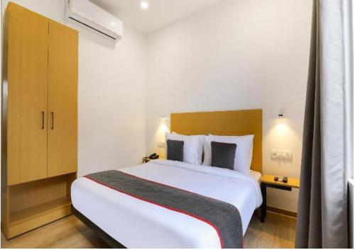 a bedroom with a large white bed in a room at Hotel Kingston House - Near Shaheed Path and Ayodhya Road in Lucknow