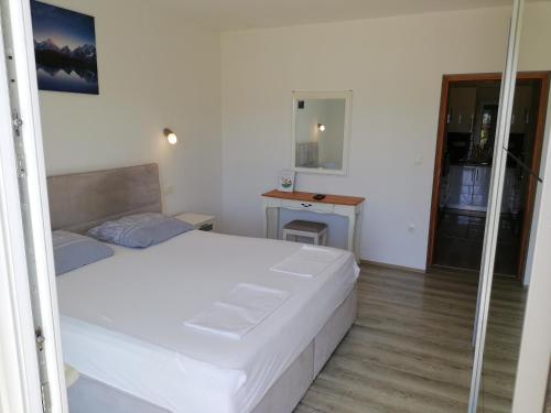 a bedroom with a large white bed and a desk at Apartment Nino in Gradac