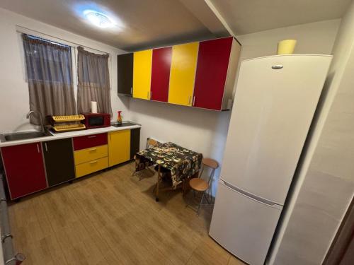 a small kitchen with a table and a refrigerator at Neptun Smart Flat in Neptun