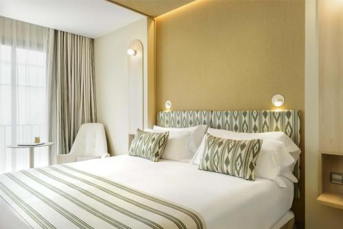 a bedroom with a large white bed with two pillows at Barceló Illetas Albatros - Adults Only in Illetas