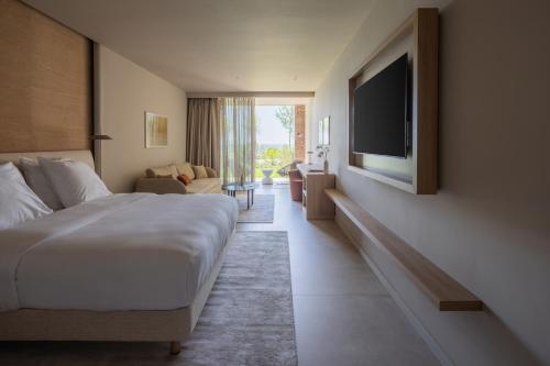 a hotel room with a bed and a flat screen tv at Green Coast Hotel MGallery Collection in Vlorë