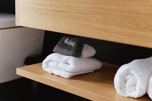 a pile of towels sitting on a wooden shelf at Kauri Lodge -Luxury waterfront in Pouto