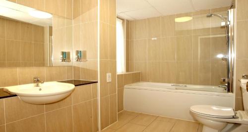 a bathroom with a sink and a toilet and a bath tub at Invercarse Hotel Dundee, BW Signature Collection in Dundee