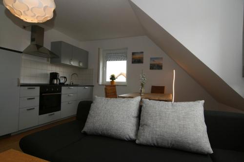 a living room with a couch and a kitchen at Ferienwohnung am turm in Mellrichstadt