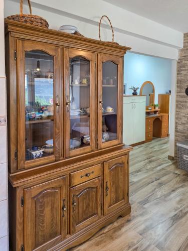 a large wooden cabinet with glass doors in a kitchen at Urban Nest in Jajce