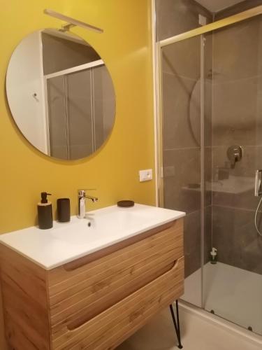a bathroom with a sink and a mirror and a shower at La Casa di Legno in Tortolì