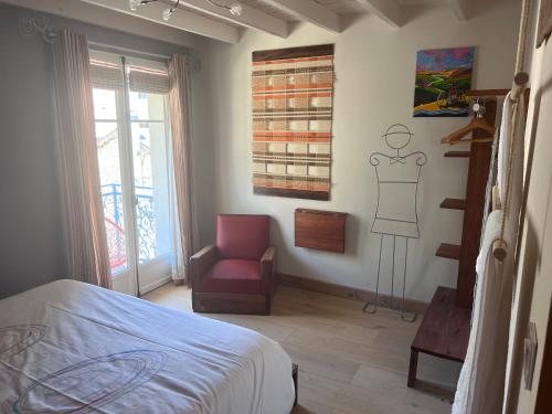 a bedroom with a mannequin on the wall and a chair at Chez Jasmine joli chapeau A vélo in Luchon