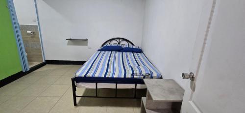 a small bed with blue sheets in a room at Hostal NicaBliss in Managua