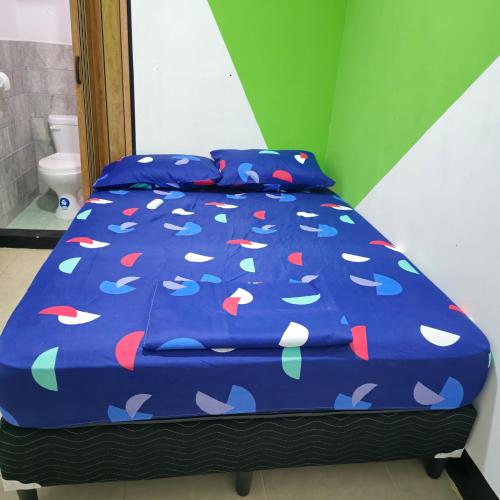 a bed with a blue comforter with hearts on it at Hostal NicaBliss in Managua