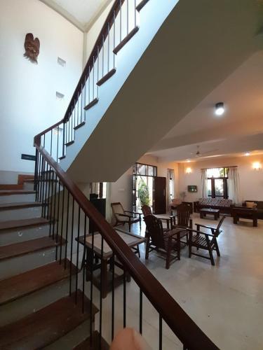 a staircase in a house with chairs and tables at Wildlight Yala in Yala