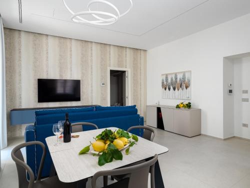 a dining room with a table and a blue couch at Blu Sky Luxury Palace Sorrento Coast in Meta