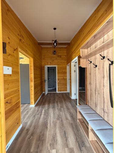 an empty room with wooden walls and wooden floors at Cozy house 7 min walk from beach in Cholpon-Ata