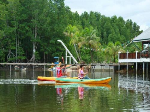 a group of children in boats on a body of water at Nov Koh Kong Resort in Phumĭ Srê Thmei