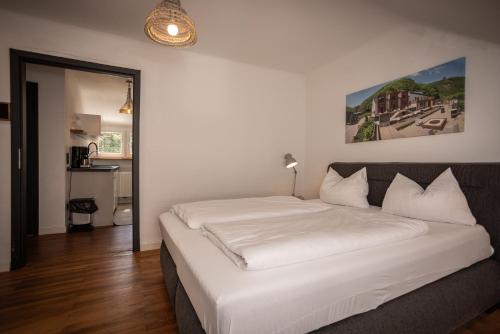 a bedroom with a large white bed in a room at Saarschleifenlodge in Dreisbach
