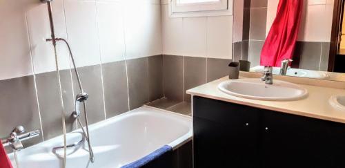 une salle de bain avec une baignoire et un lavabo dans l'établissement Appartement Rive Nature coté parc et rivière, à Saint-Raphaël