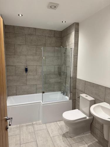 a bathroom with a tub and a toilet and a sink at Oakwood Farm Barns in Chester