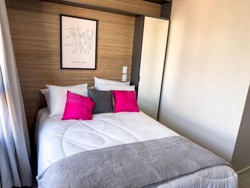 a bedroom with a white bed with pink pillows at ST Studios Vila Mariana by Housi in Sao Paulo