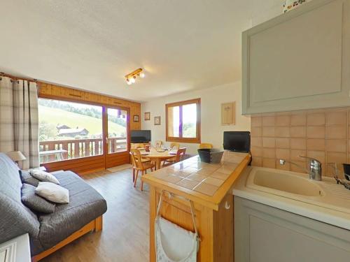 Il dispose d'une cuisine et d'un salon avec un canapé et un évier. dans l'établissement Appt 2 pièces, 6 pers, proche pistes, parking, animaux admis - FR-1-241-16, au Grand-Bornand