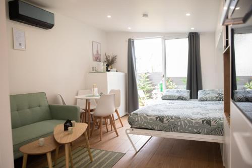 une chambre avec un lit, un canapé et une table dans l'établissement Appartement - Rez de Jardin, à Varreddes