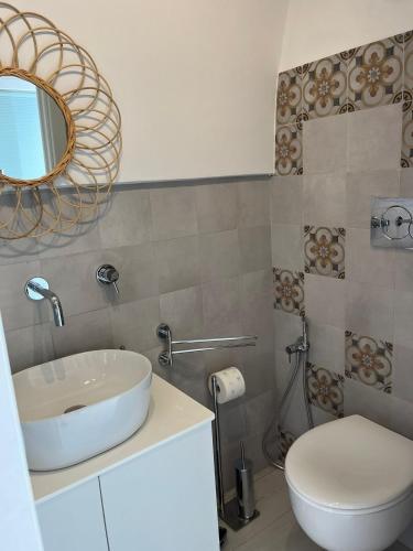 a bathroom with a sink and a toilet and a mirror at Affittacamere Nalì in Polignano a Mare