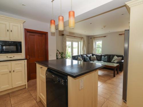 a kitchen and living room with a black counter top at Ash House in Ballyvaughan