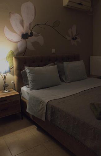 a bedroom with a bed with flowers on the wall at AMMOS in Salamís