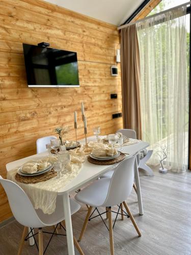 a white table with white chairs and a television on a wall at Sevanna Dream House in Tsamakaberd