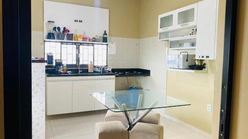 a kitchen with a glass table and two chairs at Sobrado_Familiar in Boa Vista