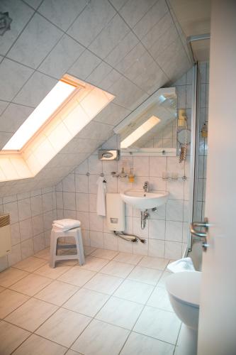a bathroom with a sink and a toilet and a skylight at Hotel Bierstübl in Sangerhausen