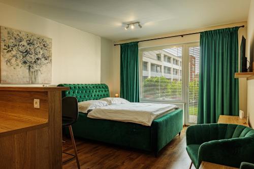 a bedroom with a bed and a window with green curtains at Rezidencia Radnica -ubytovanie- Old town in Košice