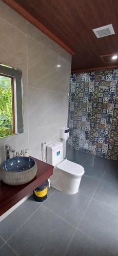 a bathroom with a toilet and a sink at Hidden Rock Tam Coc in Vũ Lâm