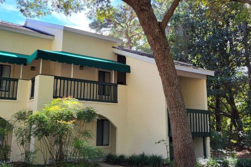 a white house with a tree in front of it at Lakeside 312 at Bluewater Bay Resort in Niceville